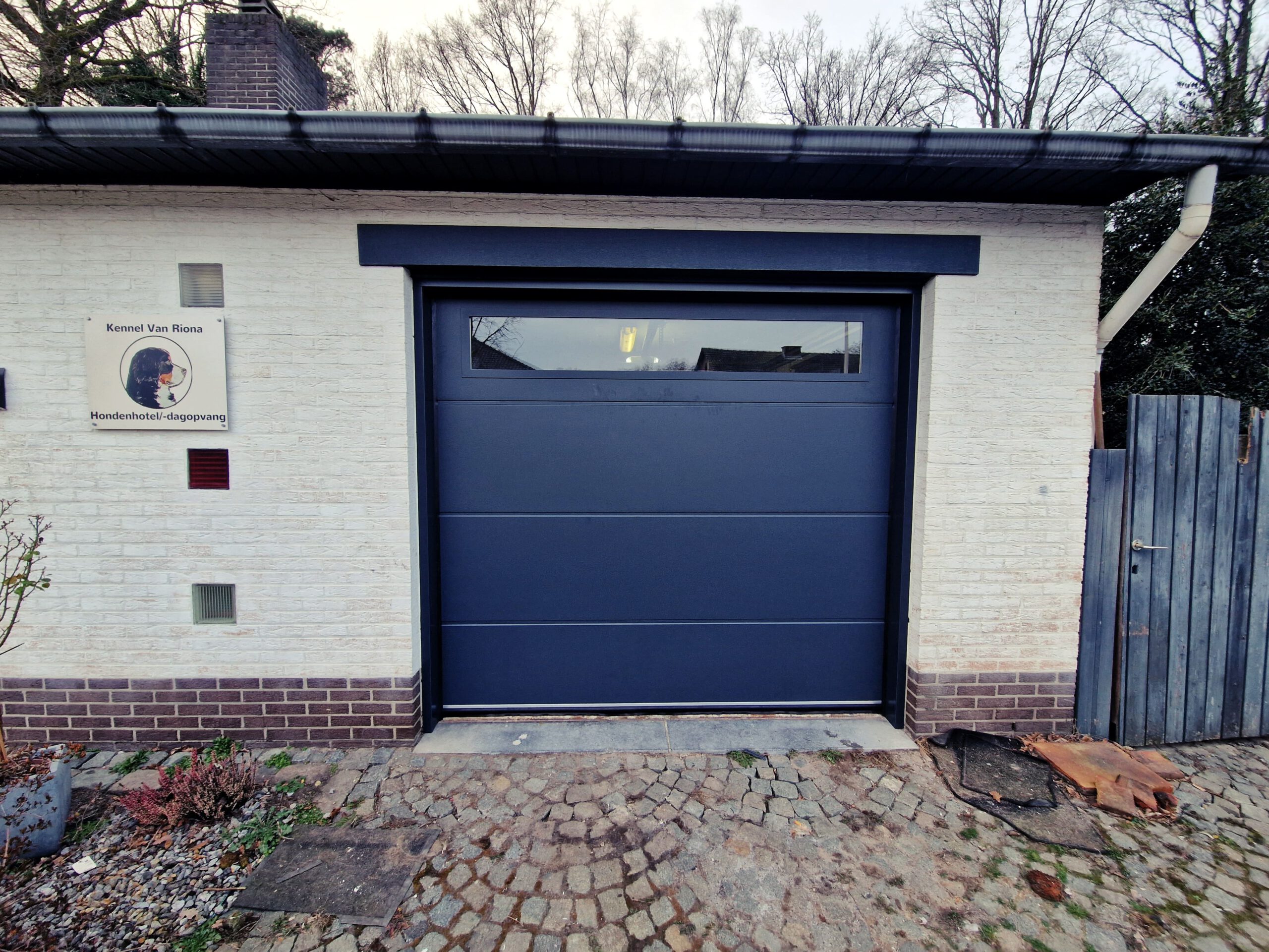 Een Nieuwe Dimensie: Garagepoort met Panoramavenster Schittert bij Kennel Van Riona Hondenhotel in Genk