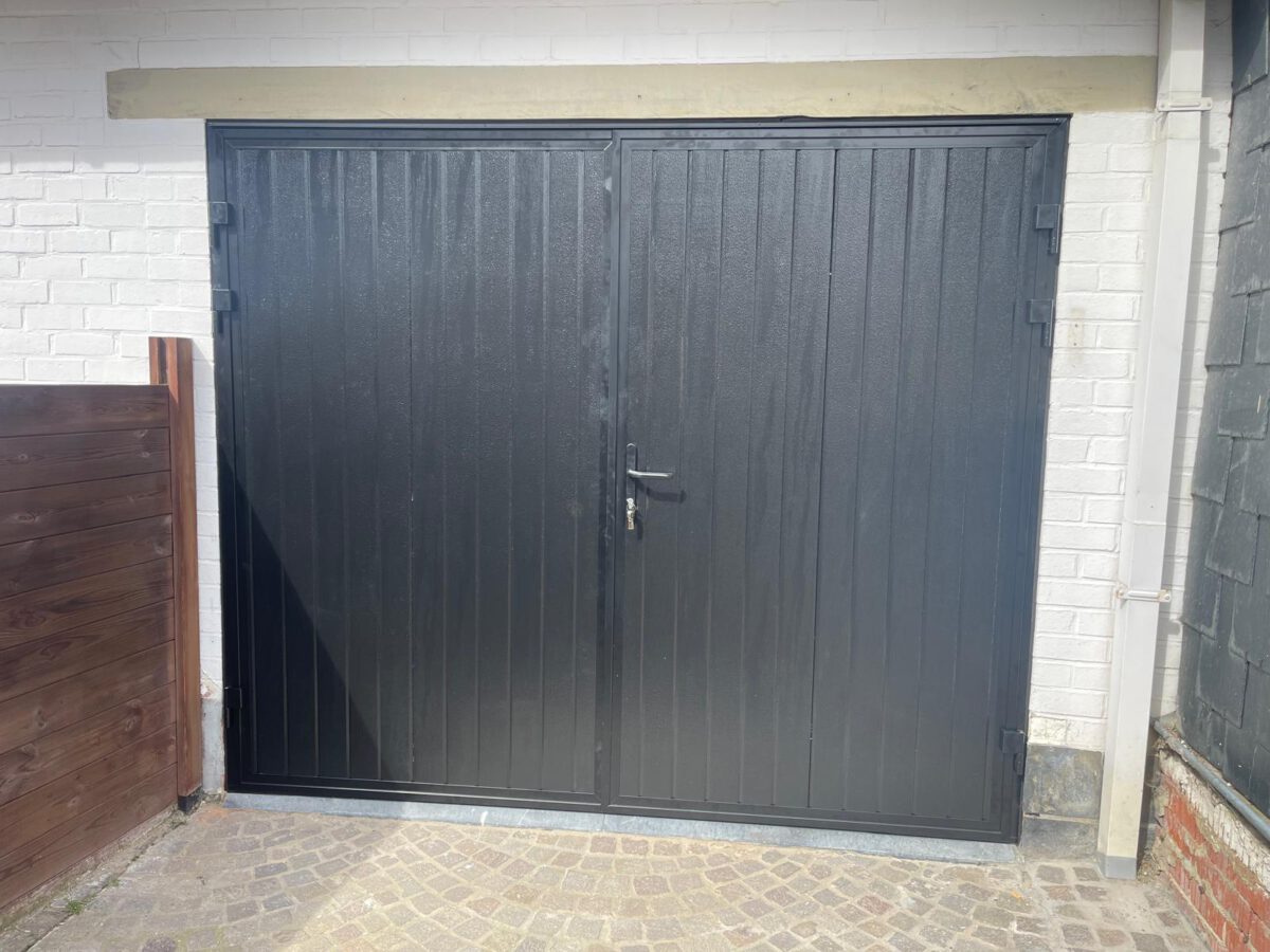 Monteurs plaatsen zorgvuldig scharnieren op de openslaande garagedeur om een naadloze en veilige afsluiting te garanderen.